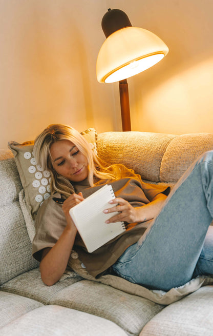 Anne van de Kerkhof relaxing on the couch on the Calmness Eco Acupressure Set while journaling