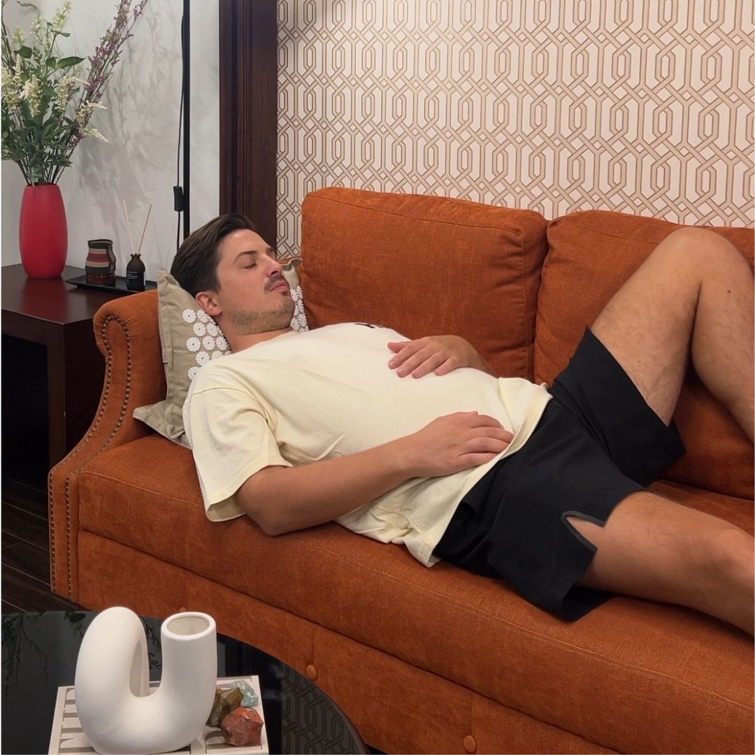 Man sleeping on the Calmness Eco Acupressure Mat on a couch